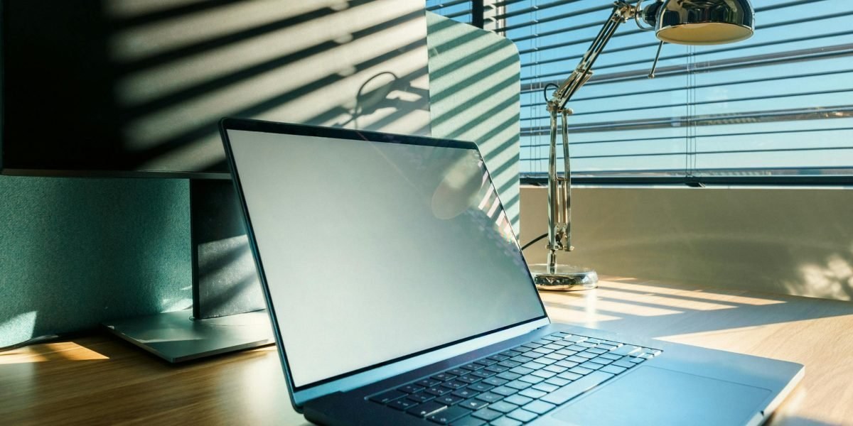 Person working remotely from home office with laptop and notebook